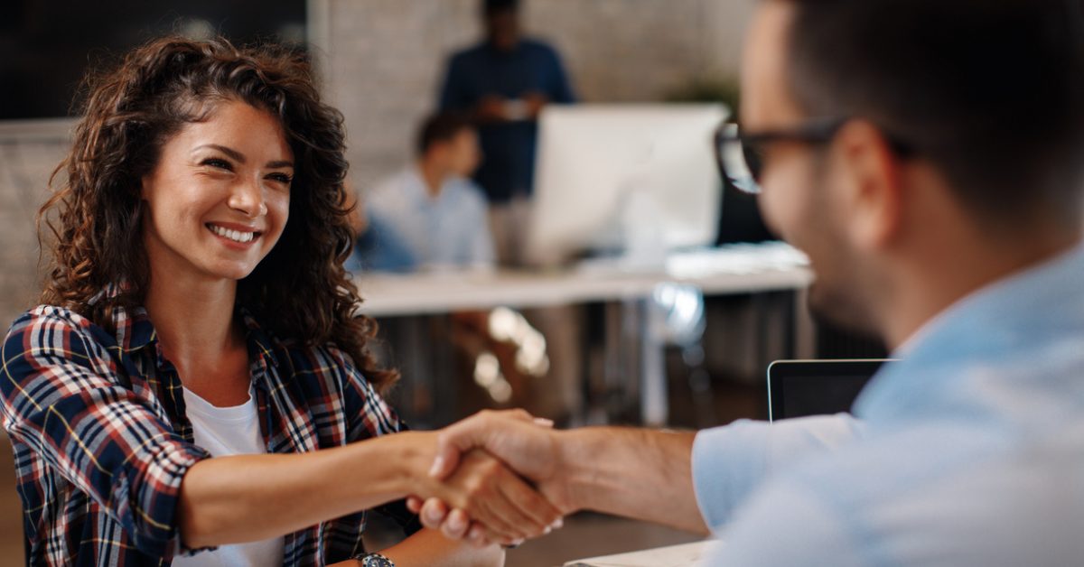 Young woman signing contracts and handshake with a manager